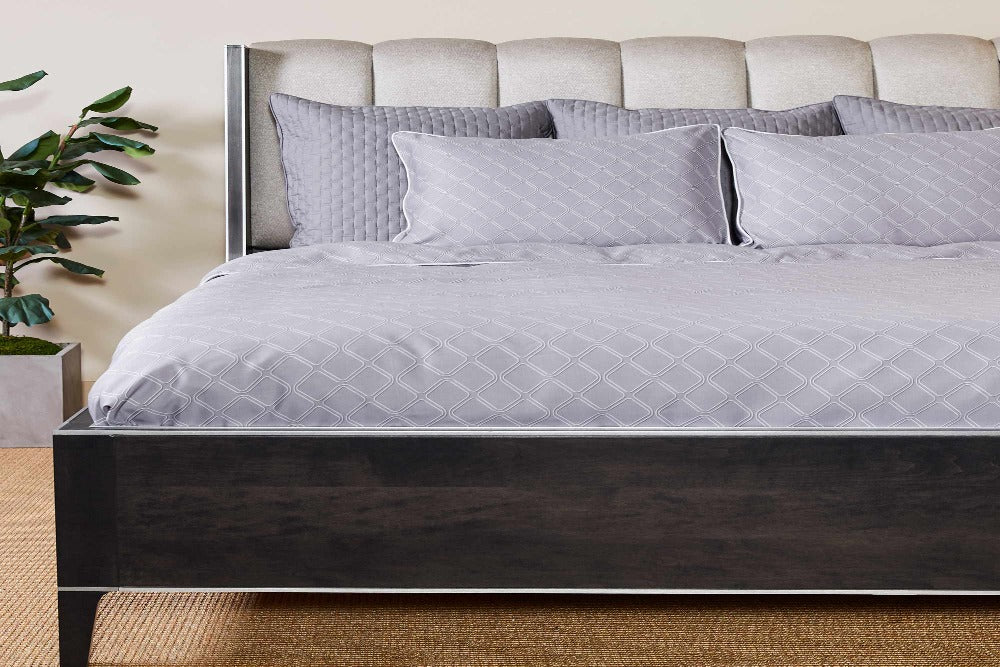 Picture of a modern bed frame and headboard smartly made up with a Platinum Geo Colored Luxurious 100% Bamboo Duvet Cover and four pillows at the headboard with matching 100% Bamboo Shams