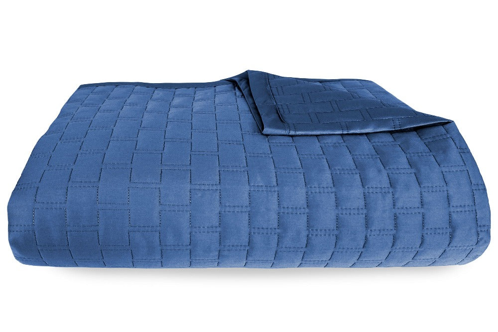 Close up view of an Indigo Colored Luxurious 100% Bamboo Quilted Coverlet neatly folded with one corner partially folded back
