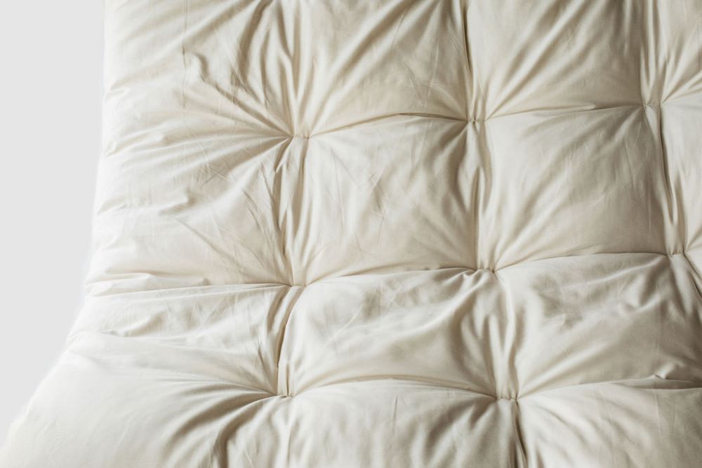Close up view of quilted mattress topper displaying the sustainably sourced bedding material