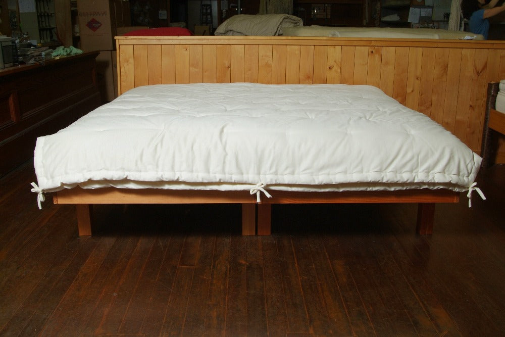 a wooden frame cali king size bed covered with an all season premium eco wool comforter