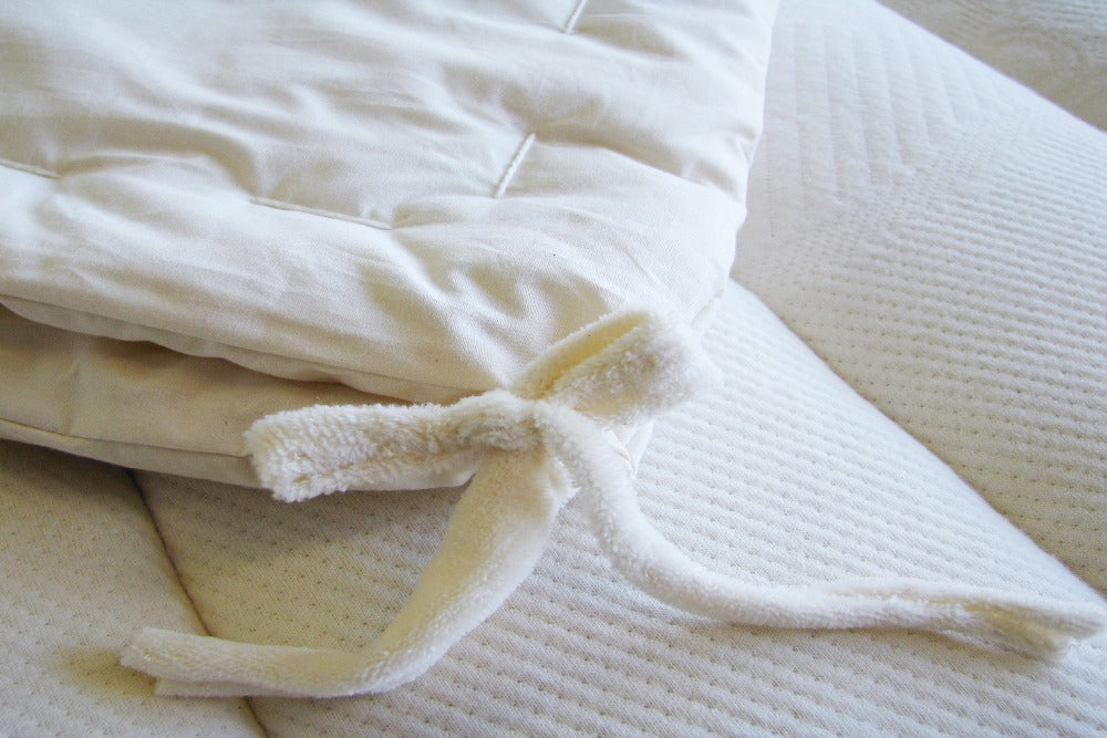 close up view of the corner ties on the all season certified organic cotton comforter filled with premium eco wool