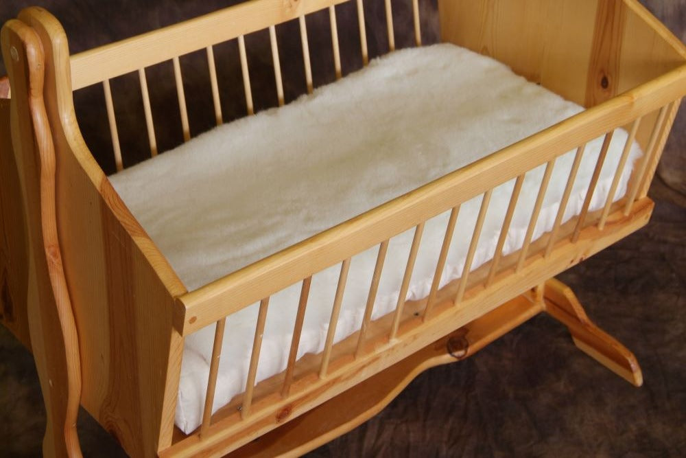 wooden bassinet with happy lamb fleece mattress topper