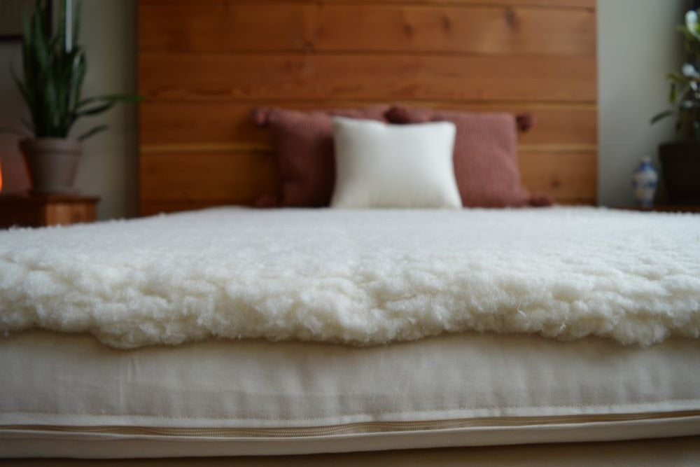 close up of happy lamb fleece covering a king size bed with knotty pine headboard and three organic cotton filled pillows