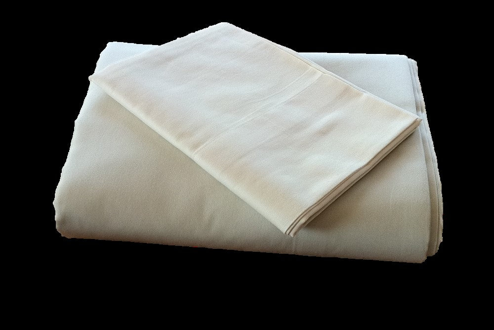 Folder organic cotton sateen pillow case laying on a folded cotton sateen sheet with black background